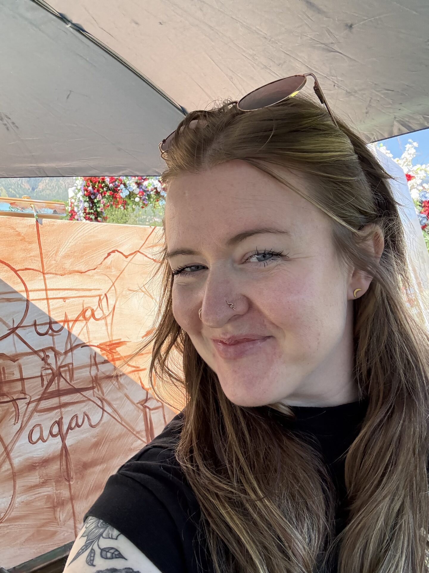 Selfie of live wedding artist Kate smiling in front of an in-progress canvas during an outdoor Colorado wedding event.
